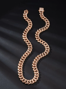 Dettaglio macro della catena cubana in oro rosa con pietre luccicanti e chiusura a incastro