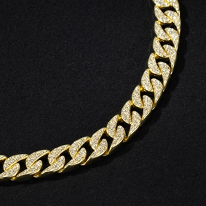 Détail macro de la chaîne cubaine dorée de 14mm avec strass brillants au style hip hop