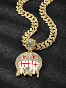 Macro shot of hip hop gold Cuban link necklace with monster pendant and iced-out zircons