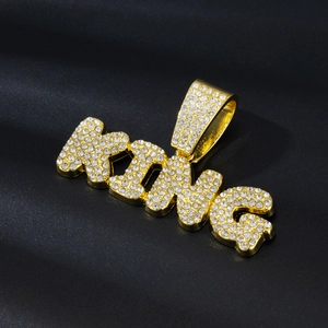 Détail d'un pendentif KING hip-hop plaqué or avec sertissage complet de strass brillants