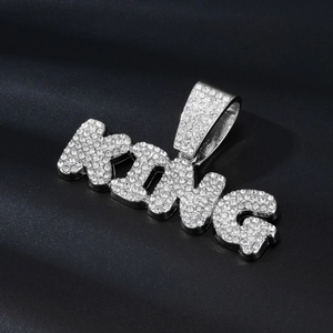 Gros plan du pendentif KING en argent serti de strass brillants sur de la soie noire