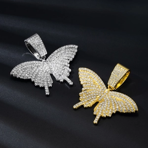 Detail of gold and silver butterfly pendants with micro-pave crystals on black satin