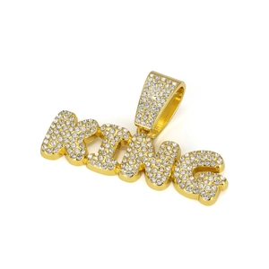 Gros plan sur le pendentif KING doré avec strass incrustés et boucle épaisse pour chaîne