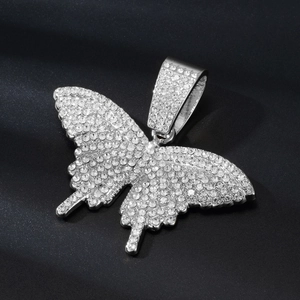 Close-up of hip-hop butterfly pendant with micro-pave crystals on black velvet