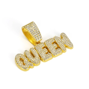 Macro shot of gold-plated QUEEN letter pendant with paved rhinestones on cuban link chain