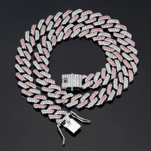 Detail of a pink and white iced-out Cuban link chain on a reflective black surface