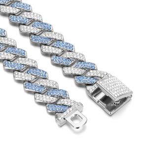 Macro view of blue and white iced-out crystals on a silver Cuban link chain with box clasp