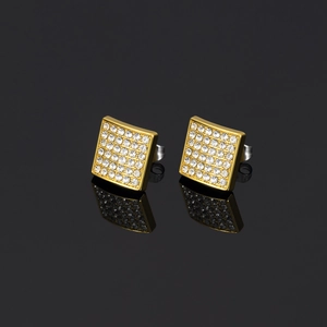 Macro shot of hip hop square stud earrings with pave crystals on gold base and black reflection