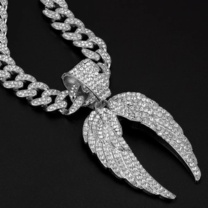 Détail macro du pendentif aile d'ange hip-hop argenté avec chaîne cubaine en diamants