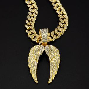 Détail d'un pendentif d'ailes d'ange avec strass sur une chaîne cubaine dorée