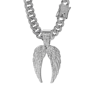 Gros plan d'une chaîne cubaine argentée hip-hop avec pendentif double aile en strass