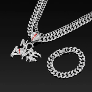Macro detail of silver iced out NO LOVE pendant on Cuban link chain with red broken heart