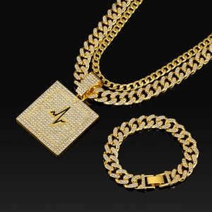 Parure bijoux hip hop dorée avec chaîne cubaine et pendentif carré serti de strass