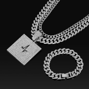 Détail de l'ensemble bijoux hip hop avec chaîne cubaine en cristal et pendentif carré