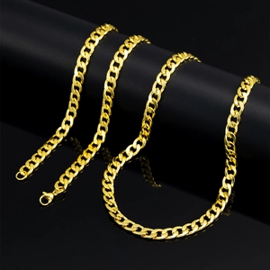 Close-up of a 7mm gold NK Cuban link chain with lobster clasp on a black display