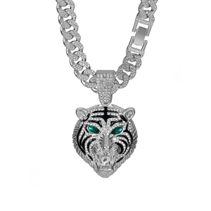 Vue détaillée du pendentif tigre argenté aux yeux verts sur une chaîne cubaine glacée