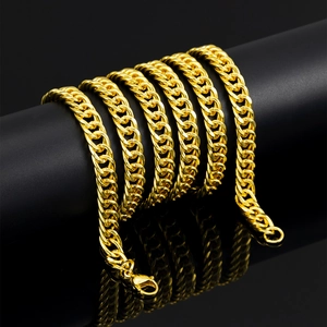 Macro view of gold 8mm Cuban link chain with lobster clasp on a black display