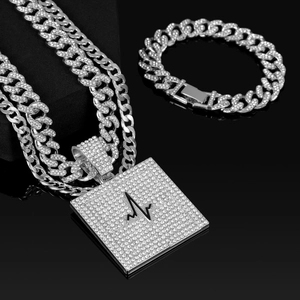 Gros plan sur l'ensemble chaîne cubaine avec pendentif carré motif rythme cardiaque