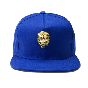Close-up of a royal blue hip-hop cap with a detailed 3D gold lion head metal emblem