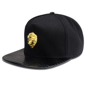 Detail of black snapback hat with golden lion metal badge and faux crocodile leather brim