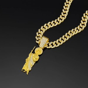 Detailed close-up of iced out gold Cuban chain and St. Jude religious portrait pendant
