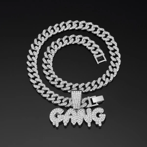Close-up of iced out GANG letter pendant on silver cuban link chain for men