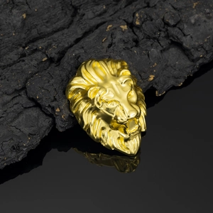 Makroaufnahme von goldenem Löwenkopf-Metallschmuck mit feinen Details auf Holzsockel