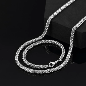 Détail d'une chaîne épi argentée avec fermoir mousqueton sur fond noir miroir