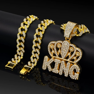 Detailed view of iced-out gold Cuban chain set with crown KING pendant and rhinestones