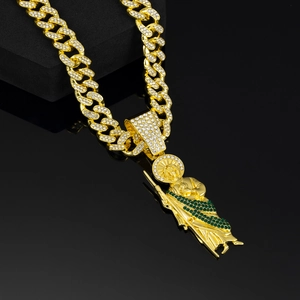 Detail of hip hop Saint Jude pendant with white crystals and green stones on Cuban link chain
