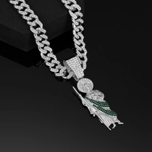Detail of St. Jude pendant with green and clear crystals on a silver Cuban chain