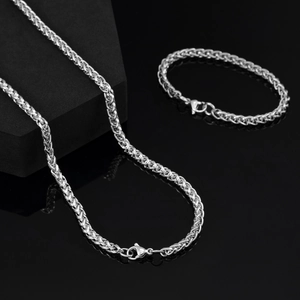 Vue détaillée du collier chaîne de blé argentée et du bracelet assorti sur miroir noir