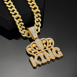 Macro view of iced out KING crown pendant with crystal paved Cuban link chain