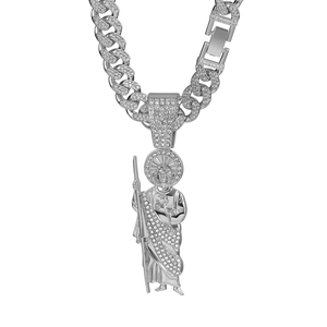 Detail of silver-tone iced out religious pendant with crystal Cuban link chain