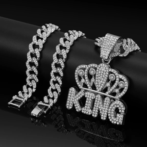 Close-up of iced out silver Cuban chain set with rhinestone-encrusted King crown pendant