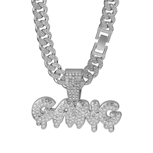 Macro detail of iced out silver Cuban link chain with GANG dripping letter pendant