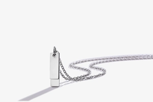 Macro shot of double polished silver rectangular pendants on a sleek titanium chain