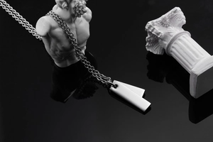 Macro shot of double rectangular tags on thick steel chain against dark reflective surface