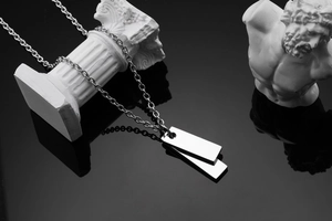 Macro shot of polished silver rectangle double pendants on a titanium steel link chain