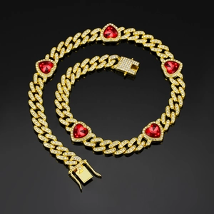 Macro detail of iced-out Cuban link jewelry set with red heart-shaped gemstones