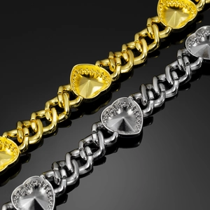 Macro detail of gold and silver Miami Cuban heart necklaces with polished texture