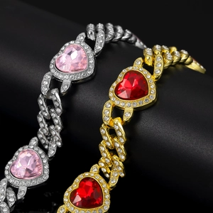 Detail of silver and gold Cuban link bracelets with pink and red heart gemstones