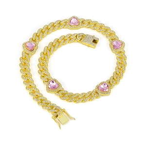 Close-up of golden Cuban link chain with pink heart gems and sparkling pave crystals