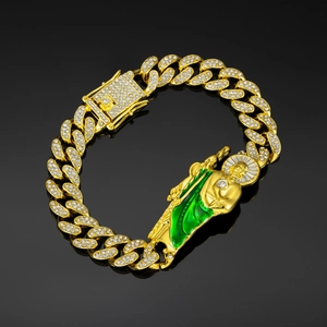 Macro detail of gold Cuban chain bracelet featuring Saint Jude green enamel and white crystals