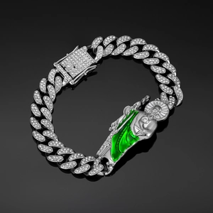 Detail of iced out Cuban link bracelet featuring Saint Jude charm with green enamel