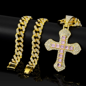 Detail of gold hip hop cross pendant with pink square crystal on cuban chain link