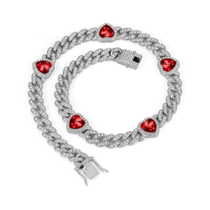 Detail view of silver iced-out cuban chain jewelry set with red heart stones