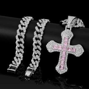 Macro detail of hip hop cross pendant with pink square gems and iced out cuban chain