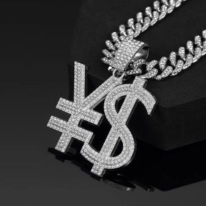 Detailed macro view of the silver iced-out dollar and yen symbol pendant on a Cuban link chain