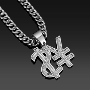 Macro shot of iced out dollar and yen sign pendant with Cuban link chain on black glass